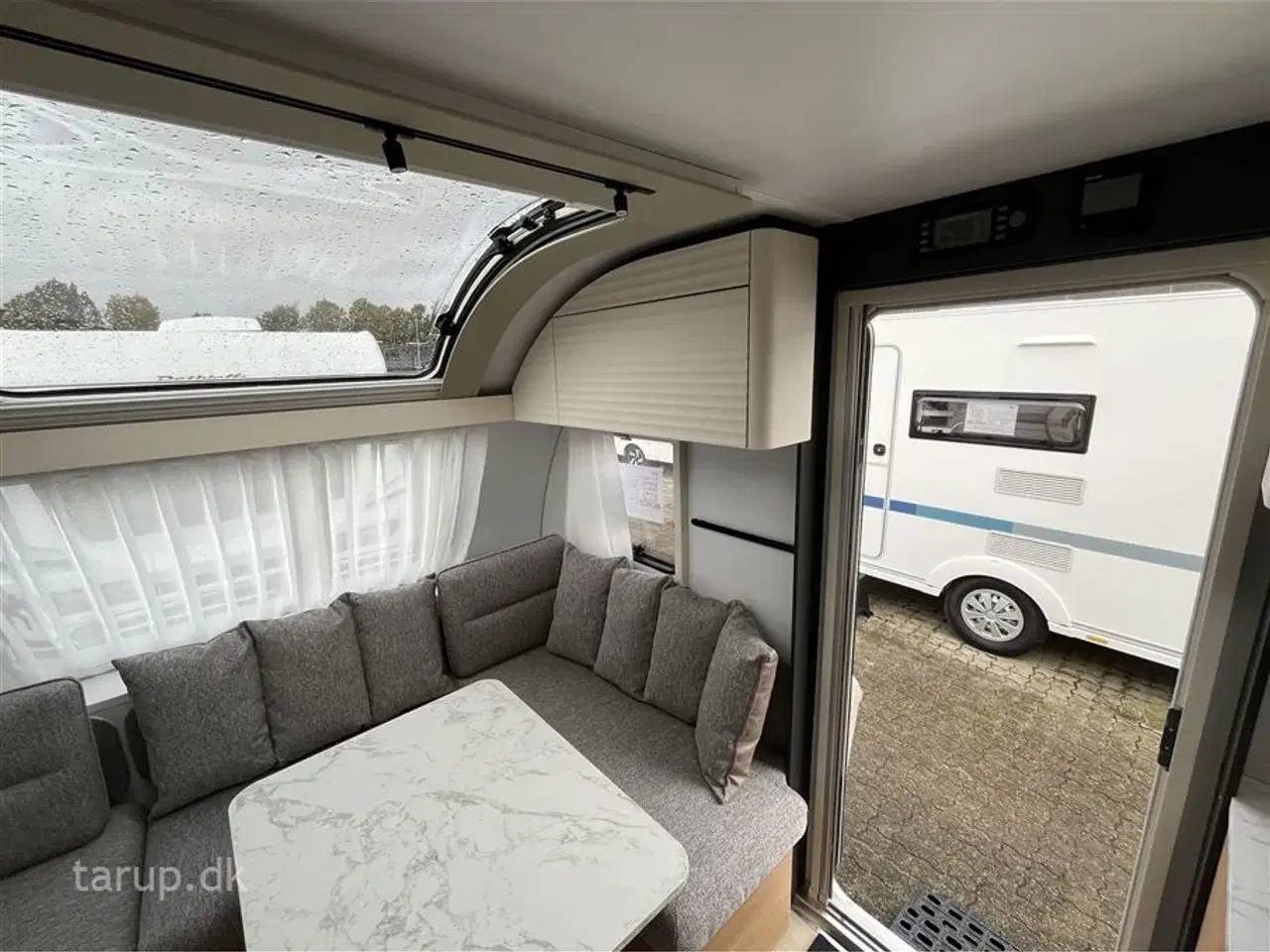 Billede 8 - 2026 - Adria Adora 572 UT   Enkeltsenge med elevation, ende-bade-værelse, panorama-vindue, el-gulvvarme, myggenetsdør, rundsiddegruppe,