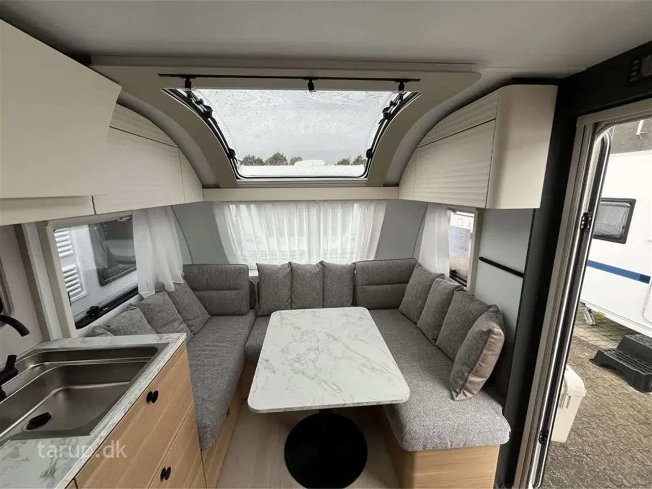 Billede 6 - 2026 - Adria Adora 572 UT   Enkeltsenge med elevation, ende-bade-værelse, panorama-vindue, el-gulvvarme, myggenetsdør, rundsiddegruppe,