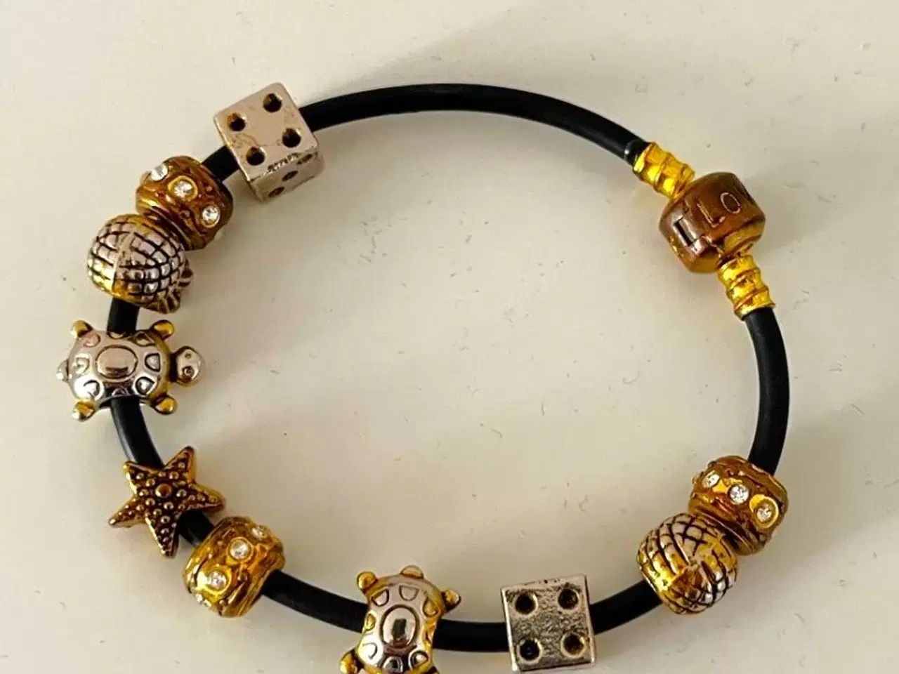 Billede 2 - Charm-armbånd på sort snøre. Sælges samlet.