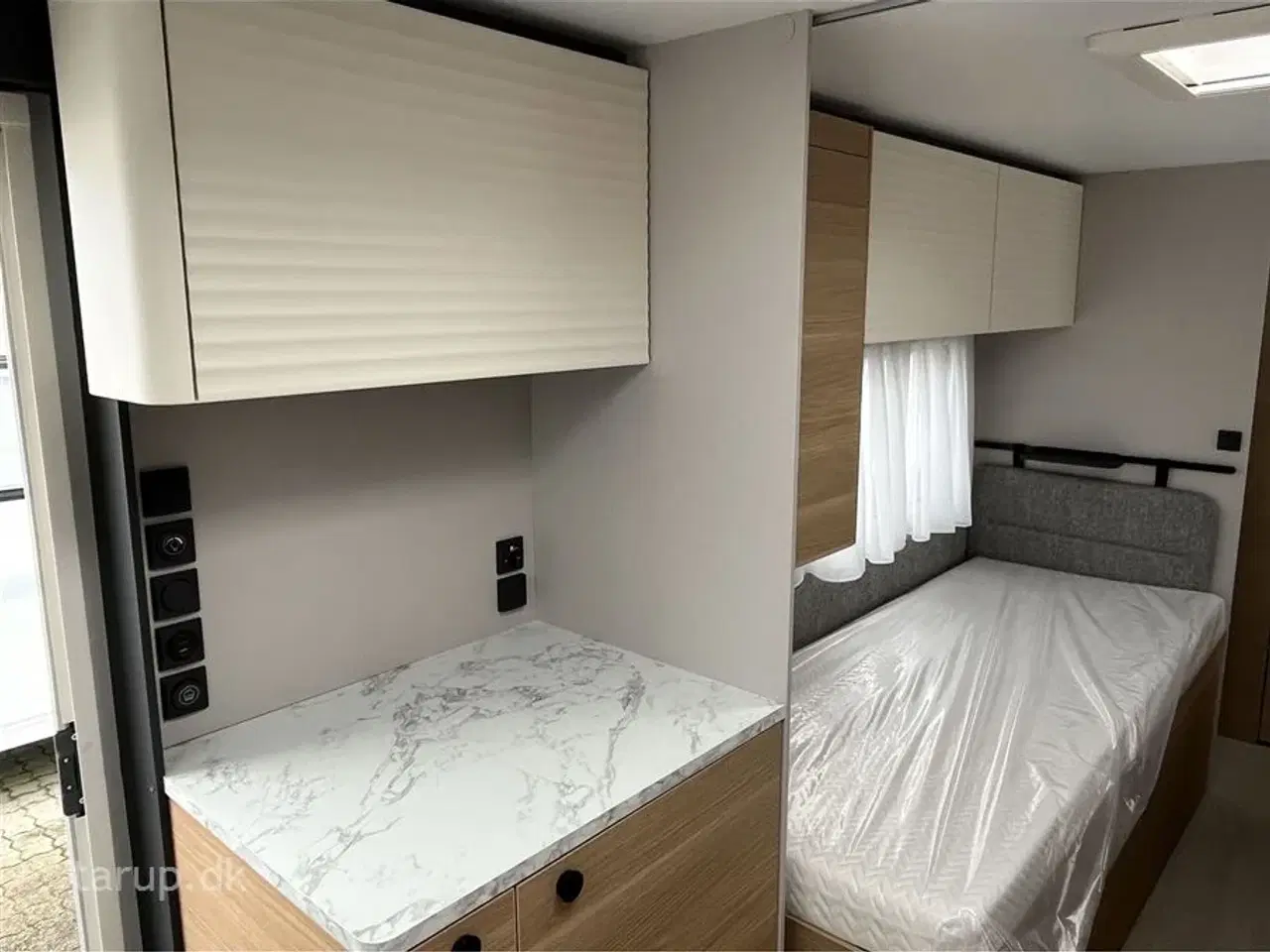 Billede 15 - 2026 - Adria Adora 572 UT   Enkeltsenge med elevation, ende-bade-værelse, panorama-vindue, el-gulvvarme, myggenetsdør, rundsiddegruppe,