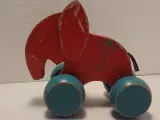 Gammel rød trækelefant i træ med skindhale