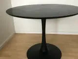 Rundt spisebord i sort askefiner med sort stål ben