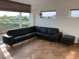 Hjørnesofa i sort læder inkl. puf