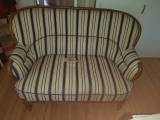 Gammel sofa med hul i betrækket 