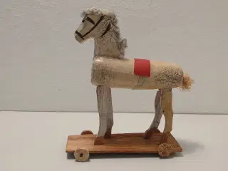Gammel træhest på hjulbræt. L 10,5cm og H 13cm.