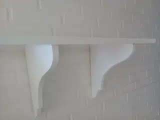 Hvid hylde med udskæringer