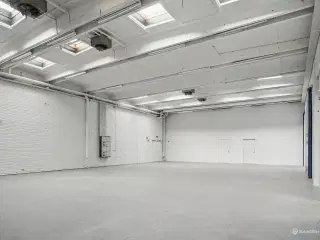 Lager på 695 m² med høj loftshøjde og to elektriske porte