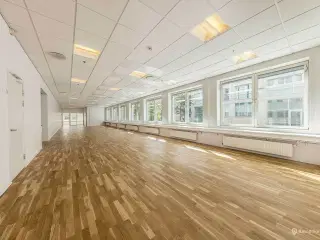 Åbent kontormiljø med adgang til fælles kantine. møderum og tagterrasse centralt i Ørestad