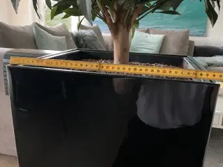 to kunstige træer i høje blomsterpotter