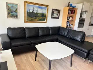 Yderst velholdt sort chaiselong-lædersofa med puf 