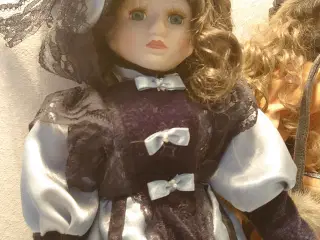 2 stk vintage porcelænsdukker på stativ.