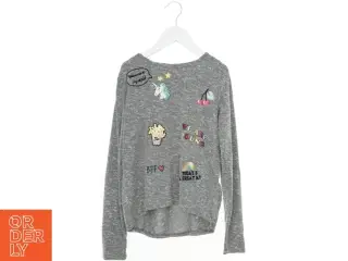 Grå bluse med farverige illustrationer fra H&M (str. 146)