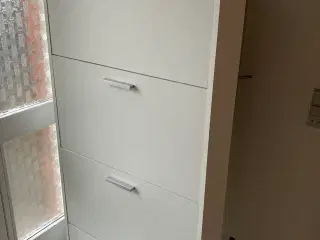 Velholdt hvidt skoskab med fire skuffer.