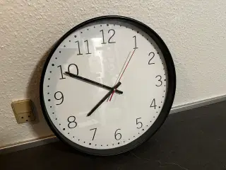Væghængt ur med hvid skive og sort kant