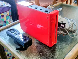 Rød Nintendo Wii med alle kabler og sort controlle