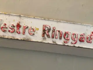 Gammelt vejskilt med skrift på begge sider