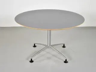 Rundt cafébord med grå laminat og filt på undersiden