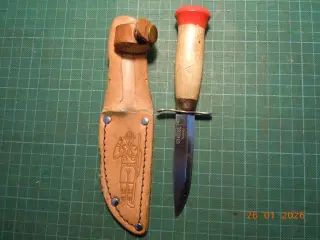 Helle spejderdolk i læderskede.