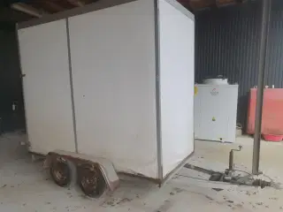 Lukket høj trailer med rampe.