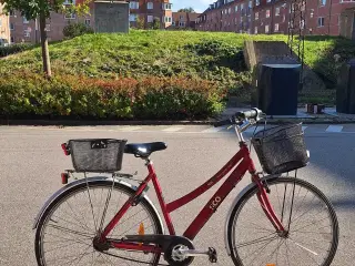 Rød cykel med to kurve og en lås monteret 