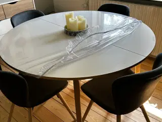 Rundt spisebord med stole.