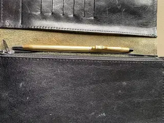 Prangerpung og guld kuglepen