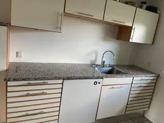 Køkken med granitbordplade og hvidevarer 