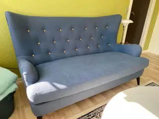 Blå sofa og stol med puf