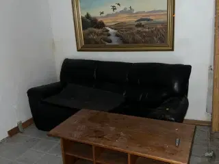 Sort lædersofa, sofabord samt indrammet maleri