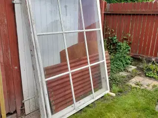 Stort tophængt vindue i træramme.