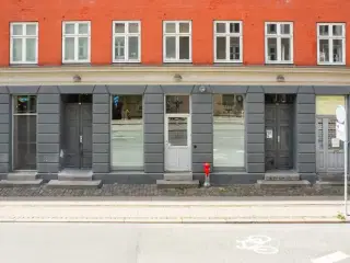 UDLEJES: Høj stuebutik med store facadevinduer og potentiale – lige ved Vesterbros Torv