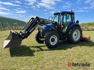 New Holland TD90D med frontlæsser og græsklipper.