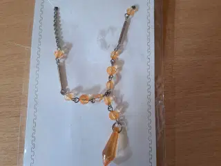 Halskæde med gyldne perler og en stor gyldne dråbe