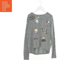 Grå bluse med farverige illustrationer fra H&M (str. 146)