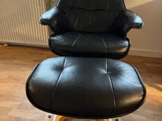 Sort lænestol i læder med fodskammel 