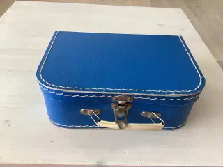 En lille blå kuffert med metal lås og håndtag 