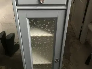 Lille skab med skuffe og spejl foroven. 