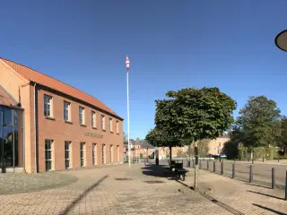 Mondæn kontorbygning på central torveplads langs Å