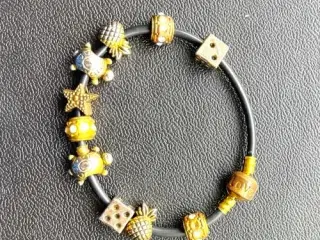 Charm-armbånd på sort snøre. Sælges samlet.