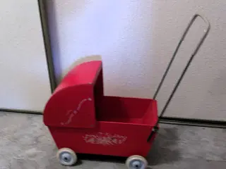 Klassisk rød dukkevogn med gummihjul.