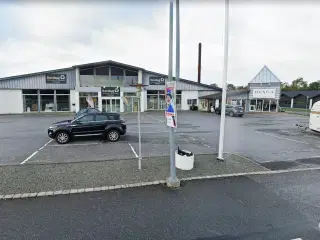 Flot butikslejemål med stor synlighed og tilhørende parkeringsarealer