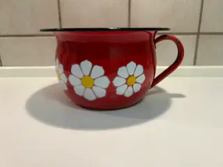 Rød emalje potte med hvid blomster på.