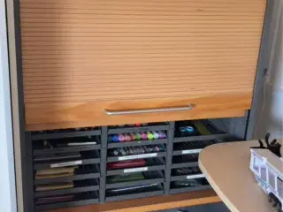 Fint skab med rulle der kan gemme tingene væk 