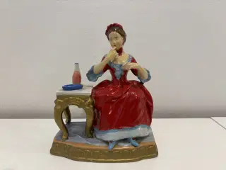 Porcelænsfigur dame ved bord/toiletbord