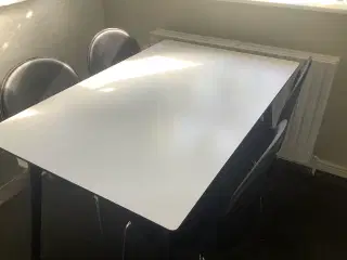 Køkkenbord med 4 stole beklædt med sort kunstlæder