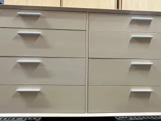 Kommode med 8 skuffer i lyst træ.