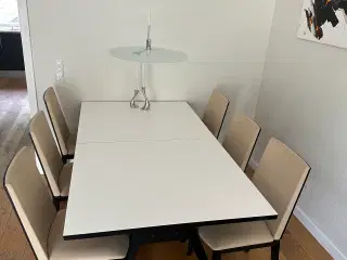 Spisebord med udtræksplader og spisestole.