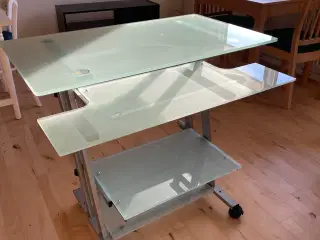 Computerbord af glas og krom.